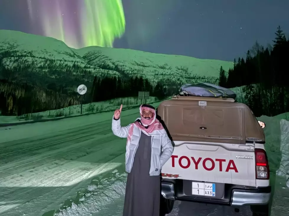 Malik Al Sultan beneath the northern lights next to his Toyota pickup